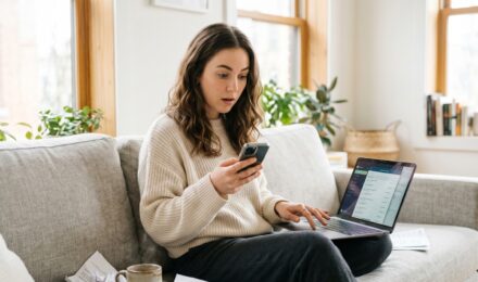 Person reviewing bank statements on laptop to perform a subscription audit and find forgotten recurring charges