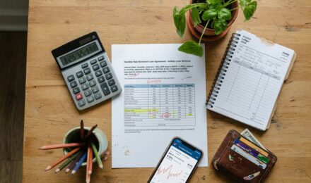 Freelancer reviewing credit card statement and invoice timeline during prime rate increase