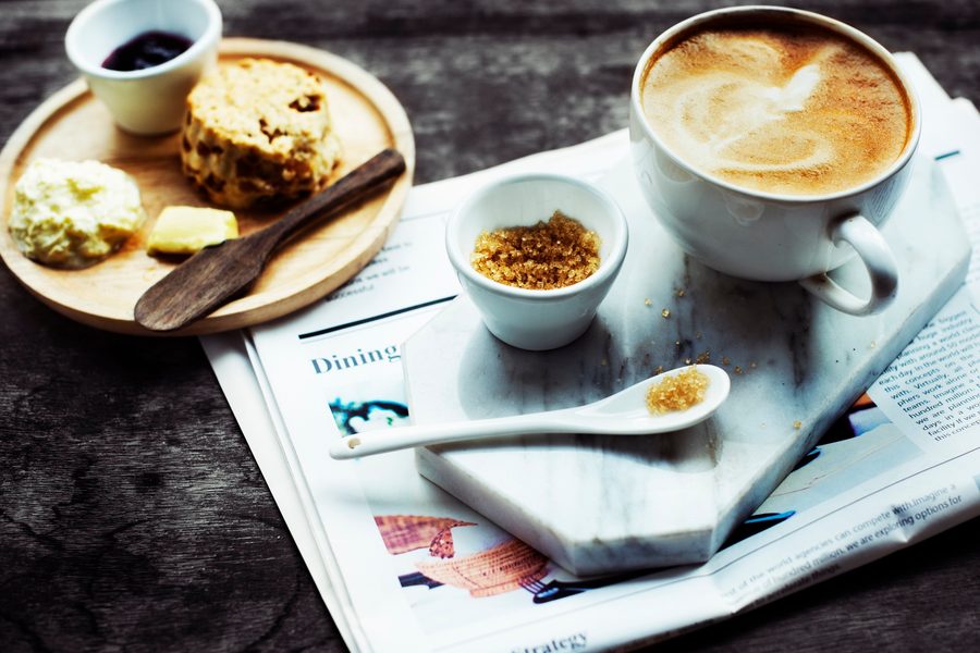 A stack of bills labeled "Credit Card 23% APR" dwarfing a small pile labeled "Daily Coffee," visualizing the wealth-eroding power of high-interest debt.