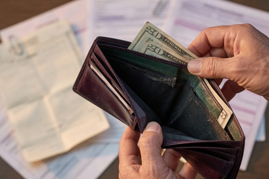 Retiree reviewing financial statements with calculator and cup of coffee