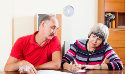 Widow reviewing financial documents and bank statements at a desk