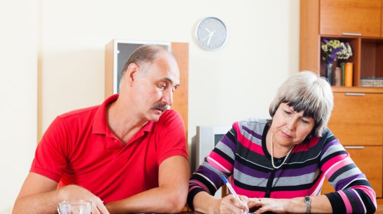 Widow reviewing financial documents and bank statements at a desk