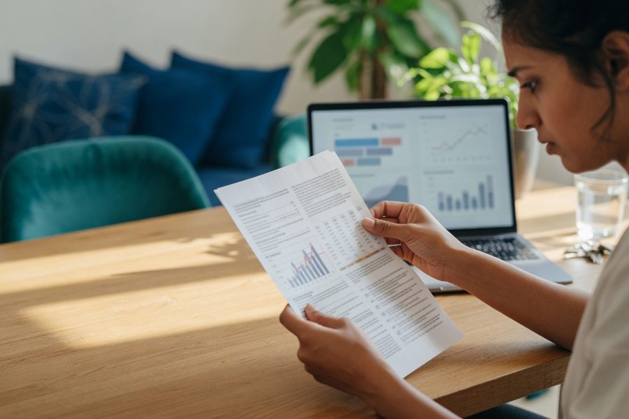 A first‑generation homebuyer reviews their credit card statement next to a mortgage pre‑approval checklist.
