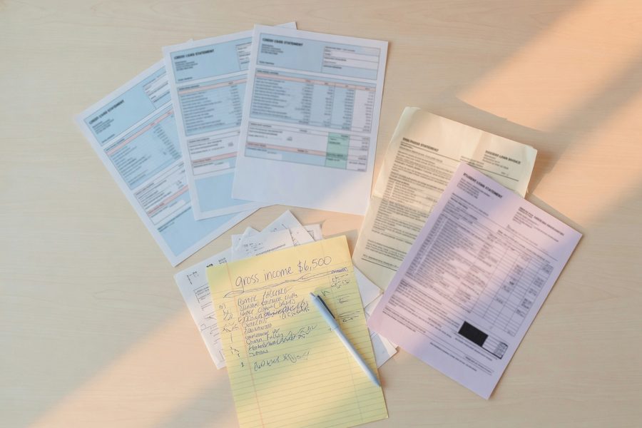 A calculator and a notepad showing a simplified debt‑to‑income formula.