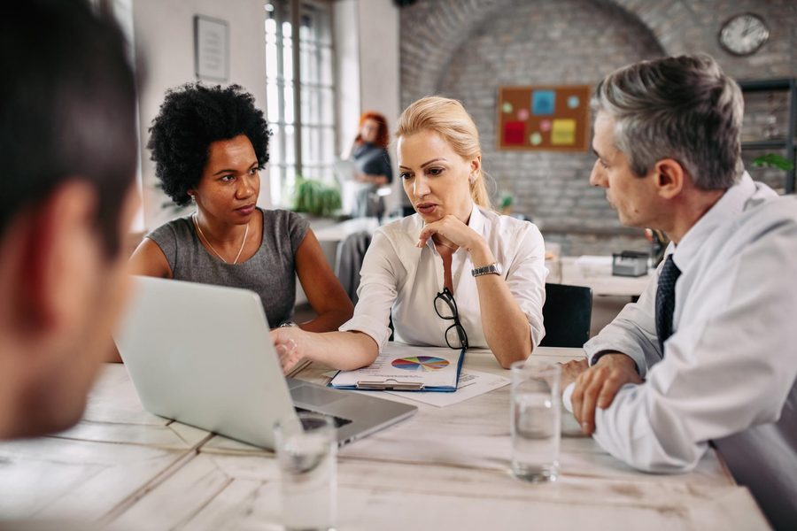 A physician reviews loan terms with a financial advisor at a desk